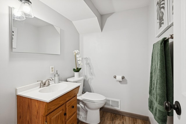 621 Irving Ave NW, Elk River, MN 55330 - bathroom with vanity, toilet, wood finished floors, and baseboards
