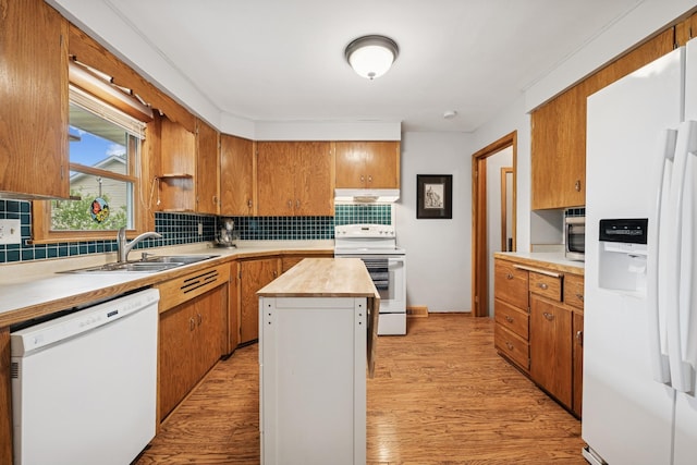 621 Irving Ave NW, Elk River, MN 55330 - kitchen featuring white appliances, a sink, decorative backsplash, light wood-type flooring, and a center island