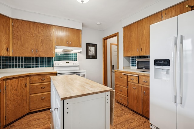 621 Irving Ave NW, Elk River, MN 55330 - kitchen with white appliances, under cabinet range hood, light wood finished floors, and backsplash