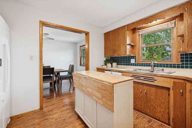 621 Irving Ave NW, Elk River, MN 55330 - kitchen with backsplash, light wood-type flooring, a sink, wooden counters, and a center island