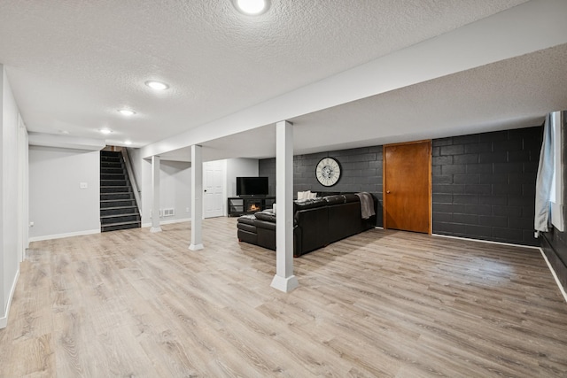 621 Irving Ave NW, Elk River, MN 55330 - finished basement featuring a textured ceiling, wood finished floors, stairs, baseboards, and recessed lighting