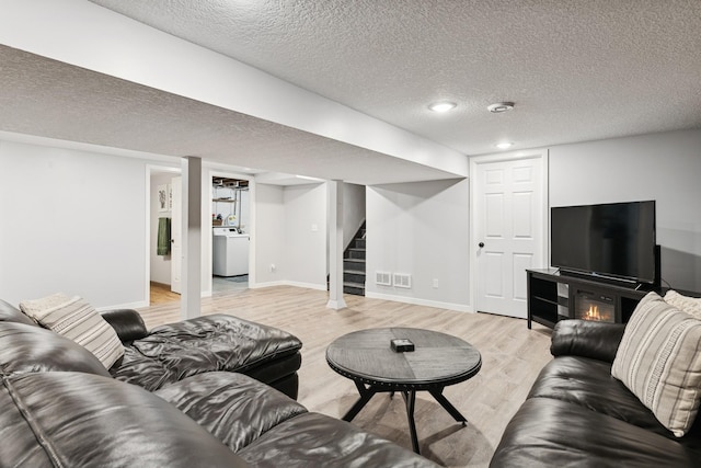 621 Irving Ave NW, Elk River, MN 55330 - living room with light wood-style flooring, a textured ceiling, stairway, washer / clothes dryer, and baseboards