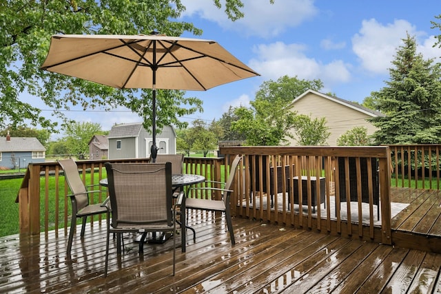 621 Irving Ave NW, Elk River, MN 55330 - wooden terrace with outdoor dining area, an outbuilding, and a yard