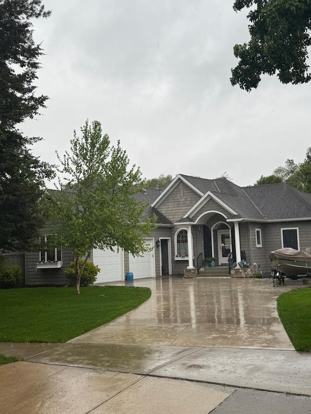 craftsman house featuring a front yard, a garage, and driveway