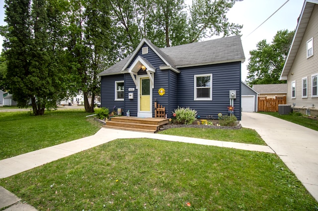 bungalow with central AC unit, an outdoor structure, concrete driveway, and a shingled roof