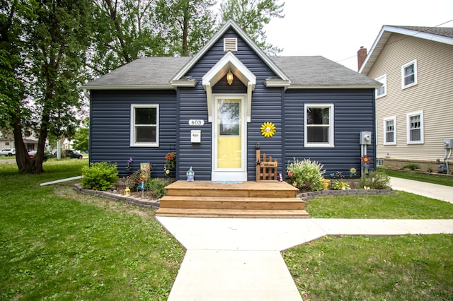 bungalow-style house featuring a front lawn