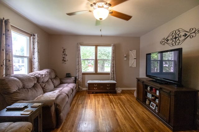 living area featuring light wood-style flooring, ceiling fan, and baseboards