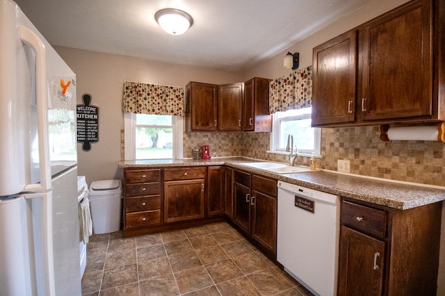 kitchen featuring white appliances, a sink, and tasteful backsplash