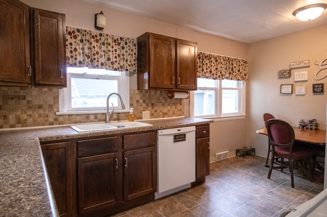 kitchen featuring dishwasher, a sink, and backsplash
