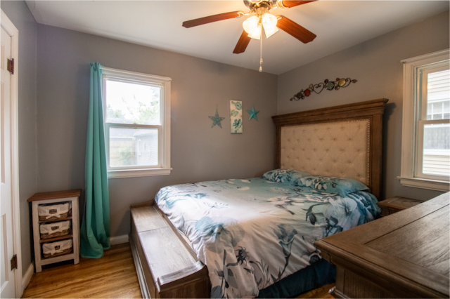 bedroom featuring light wood-style flooring, baseboards, and a ceiling fan