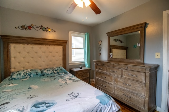 bedroom with a ceiling fan, baseboards, and wood finished floors