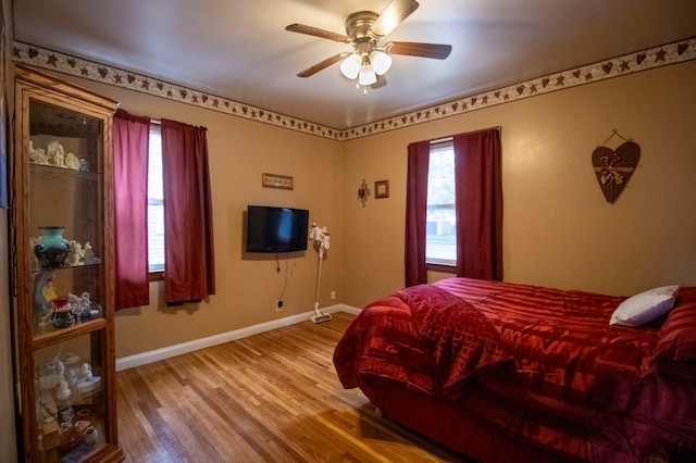 bedroom with baseboards, wood finished floors, and ceiling fan