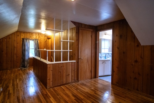 bonus room featuring wooden walls, wood finished floors, and lofted ceiling