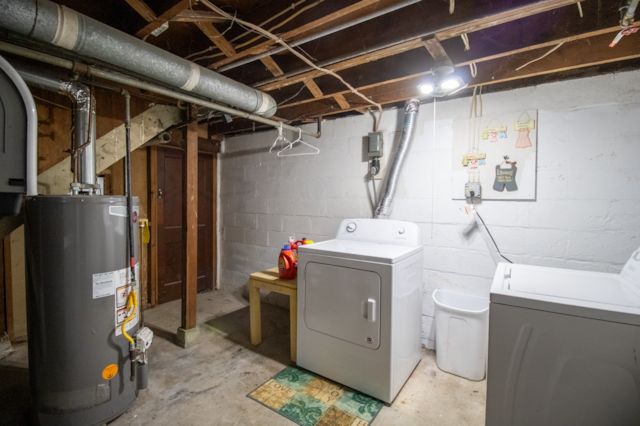 unfinished basement with gas water heater and washer and clothes dryer
