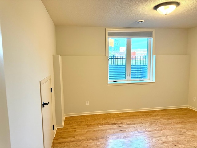 628 20th Ave S, Minneapolis, MN 55454 - spare room featuring light wood-style flooring, a textured ceiling, and baseboards