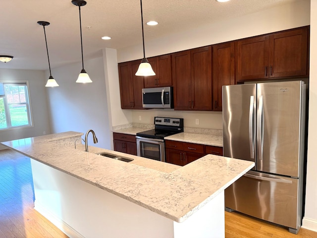 628 20th Ave S, Minneapolis, MN 55454 - kitchen featuring stainless steel appliances, a sink, light wood-type flooring, recessed lighting, and pendant lighting