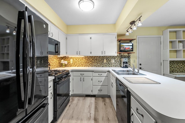 18520 29th Ave N, Plymouth, MN 55447 - kitchen featuring black appliances, light wood-style flooring, light countertops, a peninsula, and tasteful backsplash