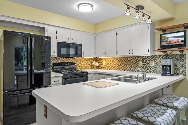 18520 29th Ave N, Plymouth, MN 55447 - kitchen with black appliances, a peninsula, light countertops, backsplash, and a kitchen breakfast bar