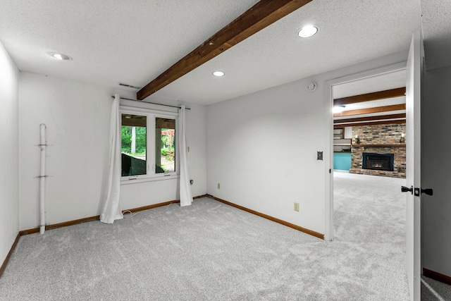 18520 29th Ave N, Plymouth, MN 55447 - spare room with carpet floors, a textured ceiling, a brick fireplace, recessed lighting, and beamed ceiling