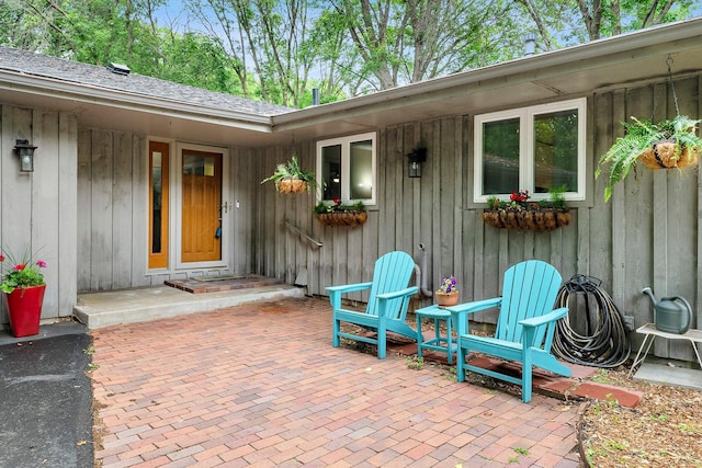 18520 29th Ave N, Plymouth, MN 55447 - doorway to property with a patio, board and batten siding, and roof with shingles