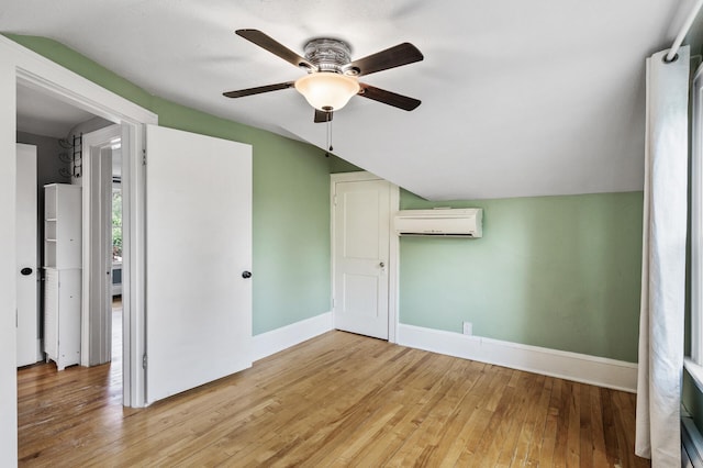 1829 Ross Ave E, Saint Paul, MN 55119 - unfurnished bedroom featuring a wall mounted AC, lofted ceiling, wood-type flooring, baseboards, and a ceiling fan