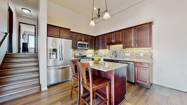 2762 134th St W, Rosemount, MN 55068 - kitchen with appliances with stainless steel finishes, backsplash, dark wood-style flooring, and pendant lighting