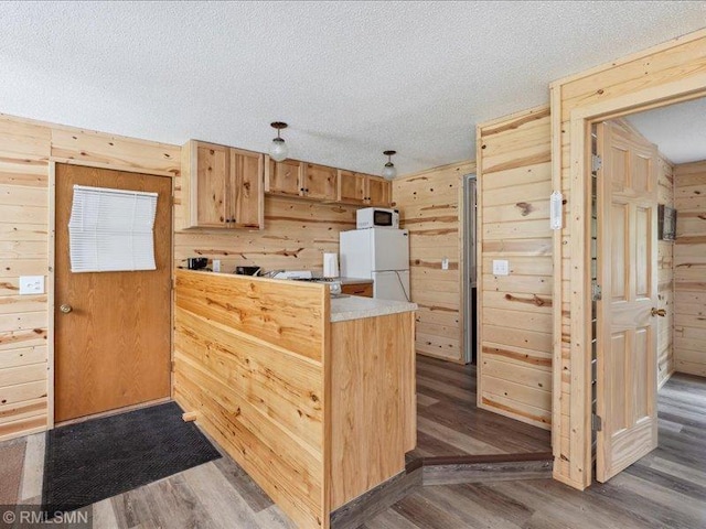 1403 County 5 NW, Hackensack, MN 56452 - kitchen with white appliances, wood walls, wood finished floors, a peninsula, and light countertops