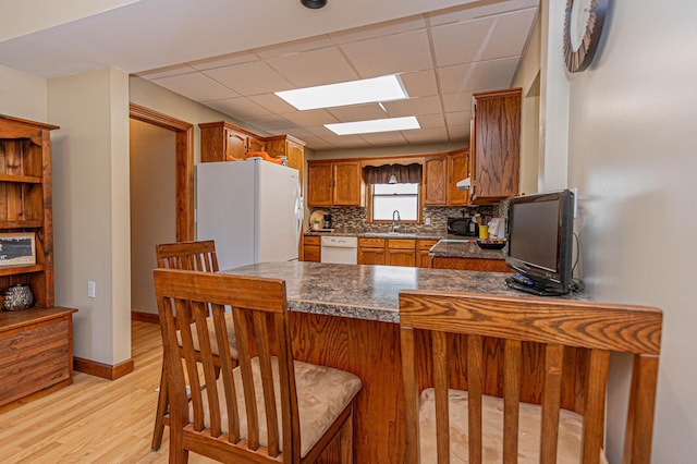 114 Iowa Ave, Hoffman, MN 56339 - kitchen featuring white appliances, a sink, a peninsula, light wood finished floors, and dark countertops