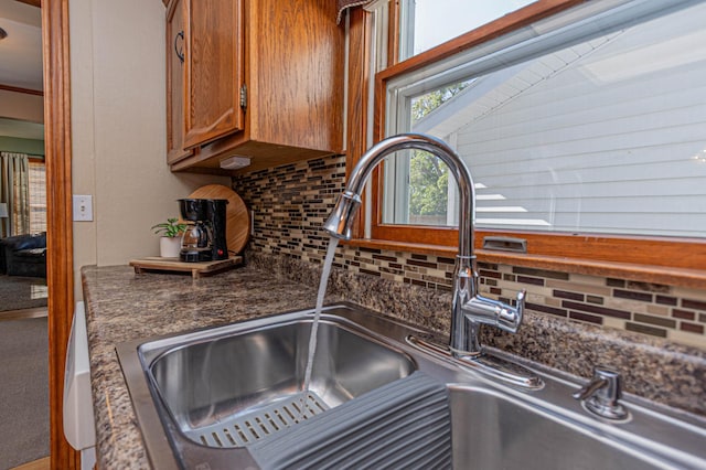 114 Iowa Ave, Hoffman, MN 56339 - kitchen view of a sink, brown cabinets, backsplash, and dark countertops