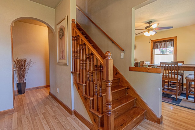 114 Iowa Ave, Hoffman, MN 56339 - stairway with arched walkways, ceiling fan, wood finished floors, and baseboards