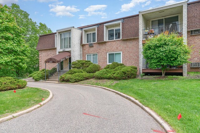 6415 York Ave S Unit 105, Edina, MN 55435 - view of front of house featuring brick siding, mansard roof, and a front lawn