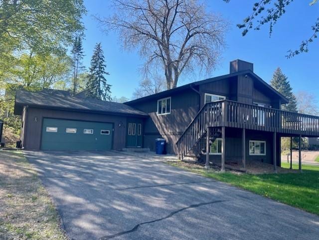 4924 Three Points Blvd, Mound, MN 55364 - view of front of house featuring an attached garage, driveway, a deck, a chimney, and stairway