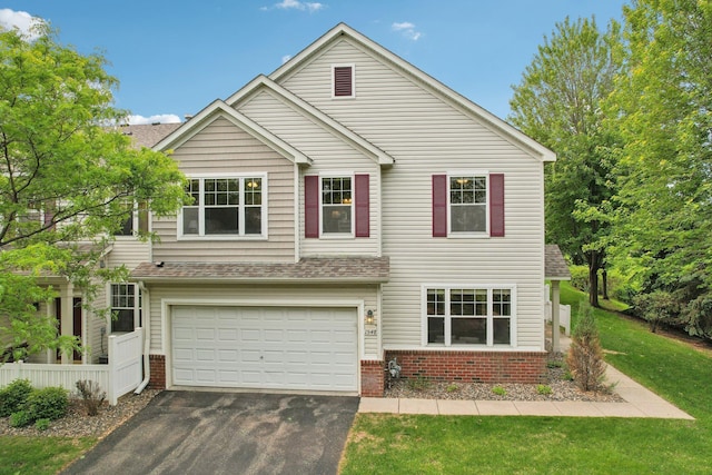 1548 Liberty Cir, Shakopee, MN 55379 - traditional-style house featuring driveway, an attached garage, brick siding, a front lawn, and roof with shingles