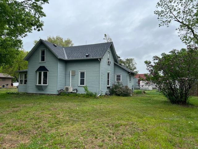 323 Weisel St, Litchfield, MN 55355 - rear view of house with a lawn and roof with shingles