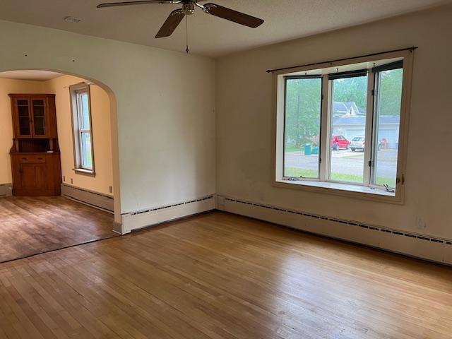 323 Weisel St, Litchfield, MN 55355 - unfurnished room with wood finished floors, ceiling fan, and arched walkways