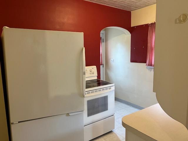 323 Weisel St, Litchfield, MN 55355 - kitchen with white appliances, arched walkways, and baseboards