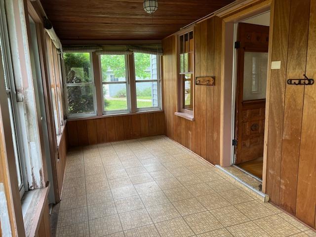 323 Weisel St, Litchfield, MN 55355 - unfurnished sunroom featuring wood ceiling, wooden walls, and tile patterned floors