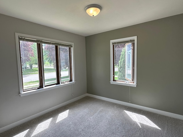 carpeted empty room with baseboards