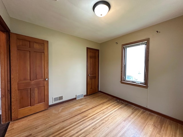 unfurnished room featuring light wood-style flooring and baseboards
