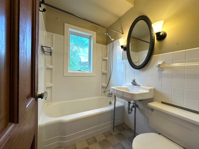 full bathroom featuring tile walls, toilet, shower / washtub combination, and a sink