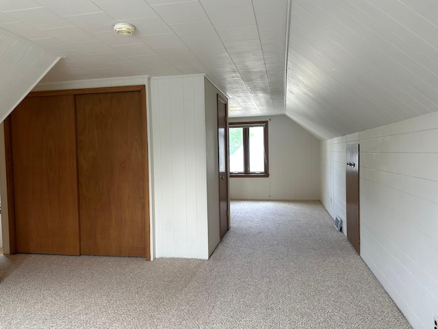 bonus room with light carpet and vaulted ceiling