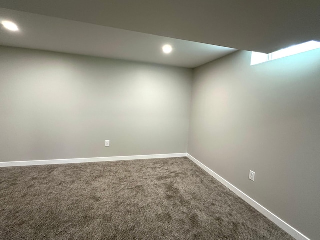 finished below grade area featuring dark colored carpet, recessed lighting, and baseboards