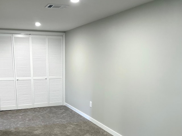 unfurnished bedroom with dark carpet, recessed lighting, a closet, and baseboards