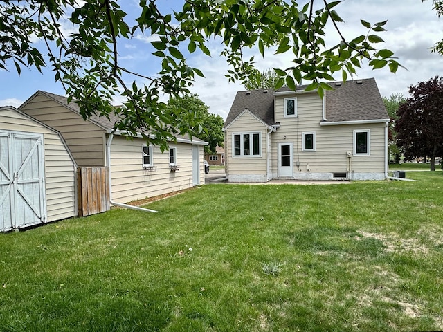 rear view of property with a storage unit, a lawn, an outdoor structure, and roof with shingles