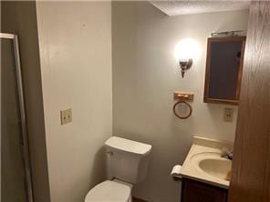 10989 Osage St NW, Coon Rapids, MN 55433 - full bath featuring vanity, a shower with shower door, and toilet