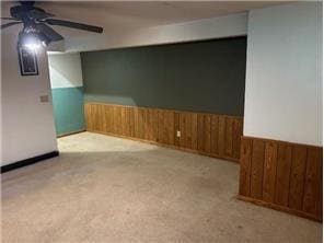 10989 Osage St NW, Coon Rapids, MN 55433 - carpeted spare room featuring ceiling fan, wainscoting, and wooden walls