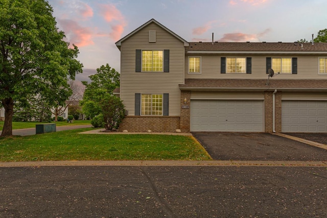 13037 Europa Trail Way N Unit A, Hugo, MN 55038 - view of front facade with brick siding, asphalt driveway, a garage, and a front lawn