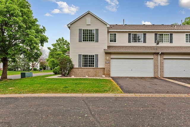 13037 Europa Trail Way N Unit A, Hugo, MN 55038 - view of front of property with brick siding, asphalt driveway, a front lawn, and an attached garage