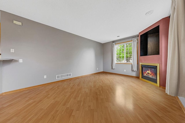 13037 Europa Trail Way N Unit A, Hugo, MN 55038 - unfurnished living room featuring light wood-style flooring, baseboards, and a fireplace