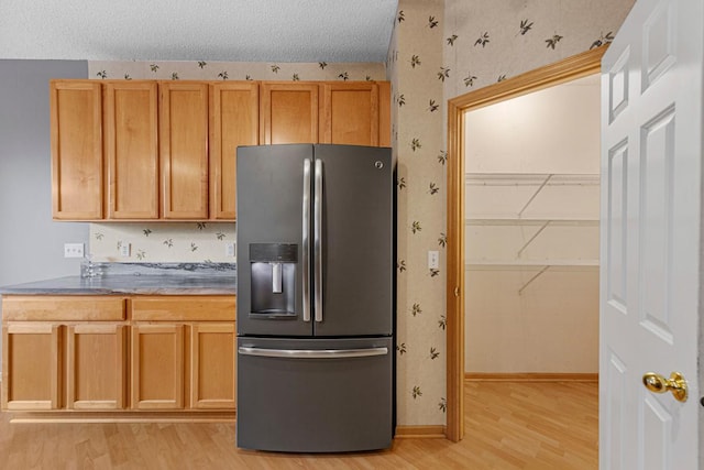 13037 Europa Trail Way N Unit A, Hugo, MN 55038 - kitchen with stainless steel refrigerator with ice dispenser, light wood finished floors, wallpapered walls, baseboards, and a textured ceiling